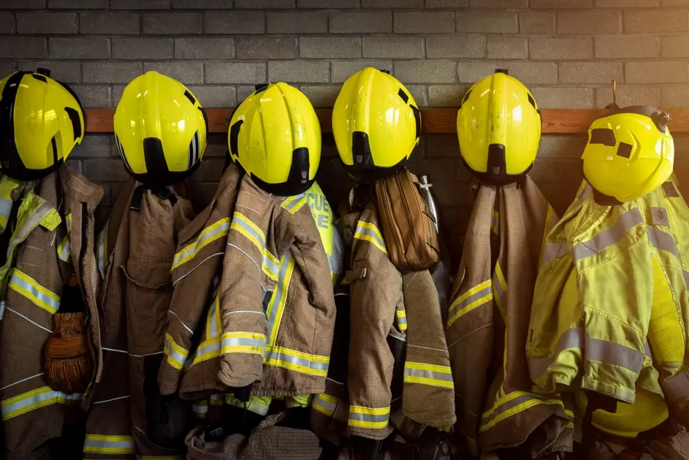 Casques jaunes et équipements de protection suspendus dans un centre de formation pour pompiers d'une école du feu.
