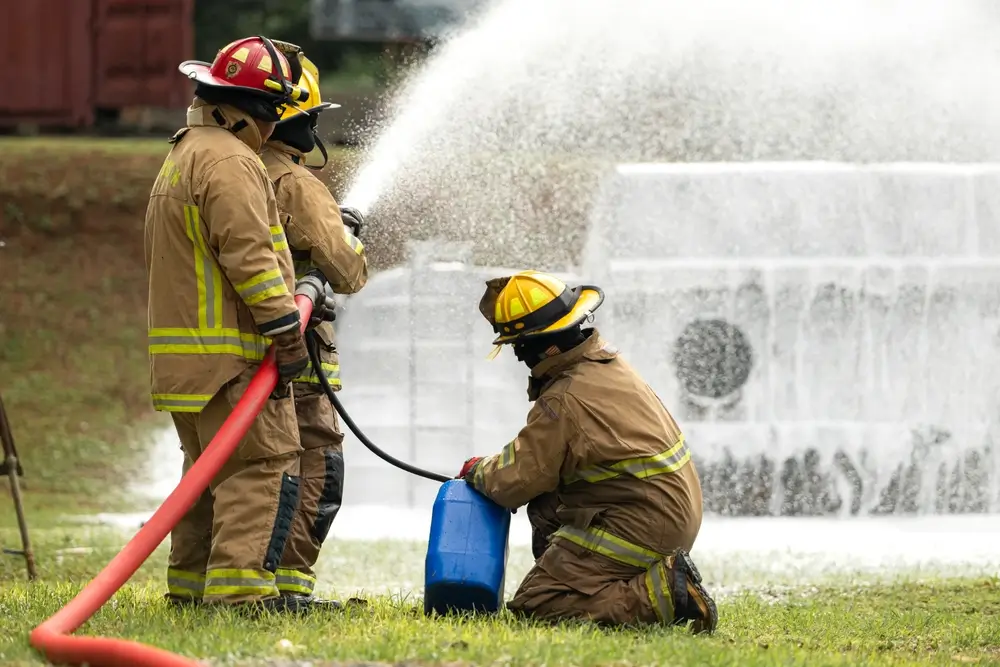 Pompiers en formation manipulant une lance à incendie lors d'un exercice