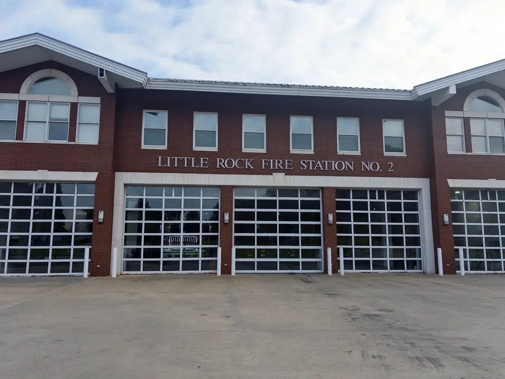 Façade d'une caserne de secours avec de grandes baies vitrées pour le passage des véhicules d'intervention.
